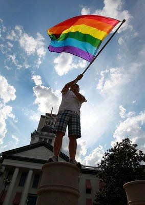 Mitchell Maxey waves a rainbow flag in front of the Florida Capitol in June 2013.