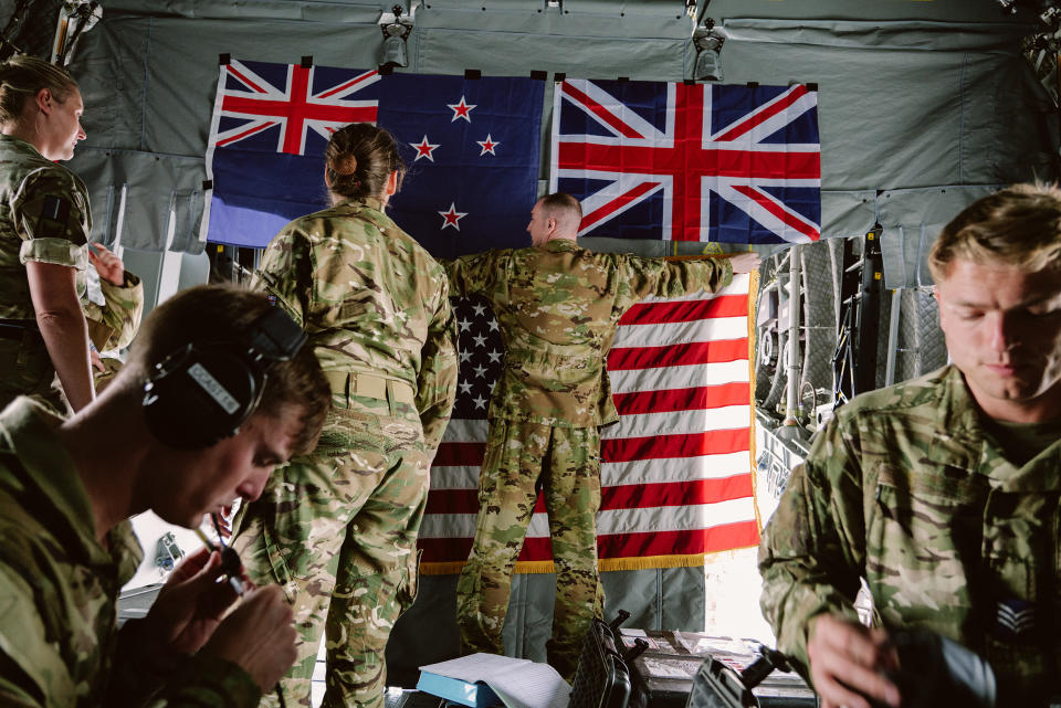 British forces hang the American flag under New Zealand and Britain's flags inside  an Airbus A400M at Hickam Field in Honolulu, (Josiah Patterson for NBC News)