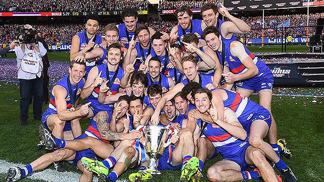 The victorious Bulldogs team poses with the AFL premiership trophy. Pic: Getty