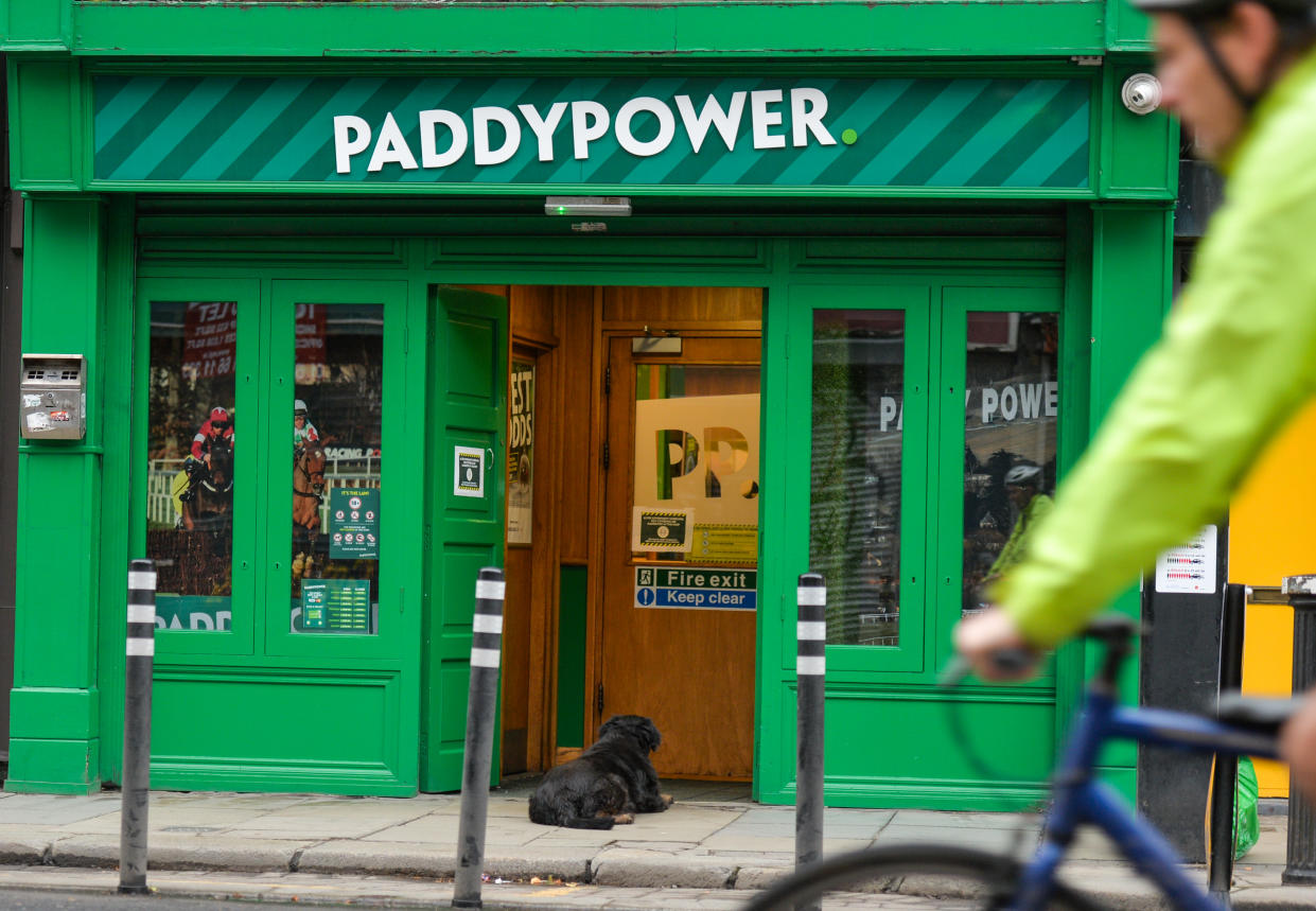 Flutter  A dog awaits for his owner outside Paddy Power office in Dublin city centre on St. Stephen's Day. Taoiseach Micheal Martin announced on December 22nd a series of new Level 5 restrictions designed to contain the spread of the coronavirus.Among them are restrictions on the movement of people and the opening of all non-essential retail shops (shops may remain open but have to postpone January sales). The Department of Health reported today a new daily record of new cases for the Republic of Ireland, with 1,296 new cases and 6 deaths (2,294 new cases and 26 deaths confirmed on the island of Ireland).On Saturday, December 26, 2020, in Dublin, Ireland. (Photo by Artur Widak/NurPhoto via Getty Images)