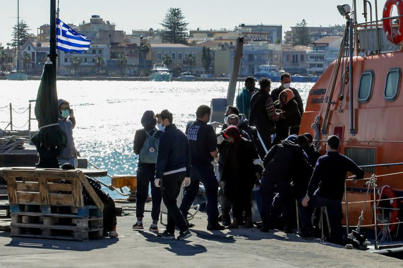 Migrants disembark a Hellenic Coast Guard vessel after being rescued at open sea, on the island of Chios