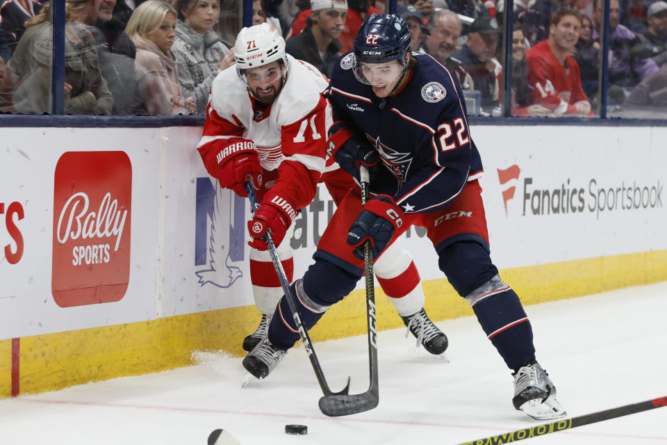 Detroit Red Wings' Dylan Larkin, left, and Columbus Blue Jackets' Jake Bean, right, chase the puck during the first period of an NHL hockey game Monday, Oct. 16, 2023, in Columbus, Ohio. (AP Photo/Jay LaPrete)