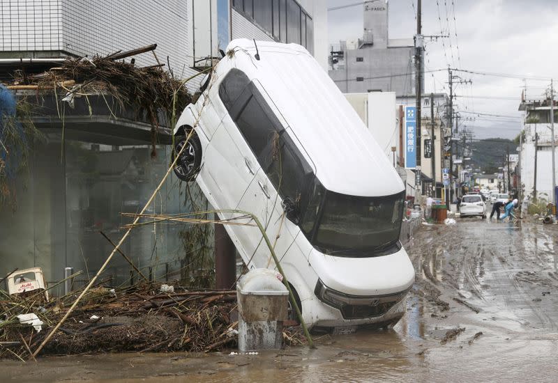 A car is pictured after it was drifted by torrential rain in Hitoyoshi