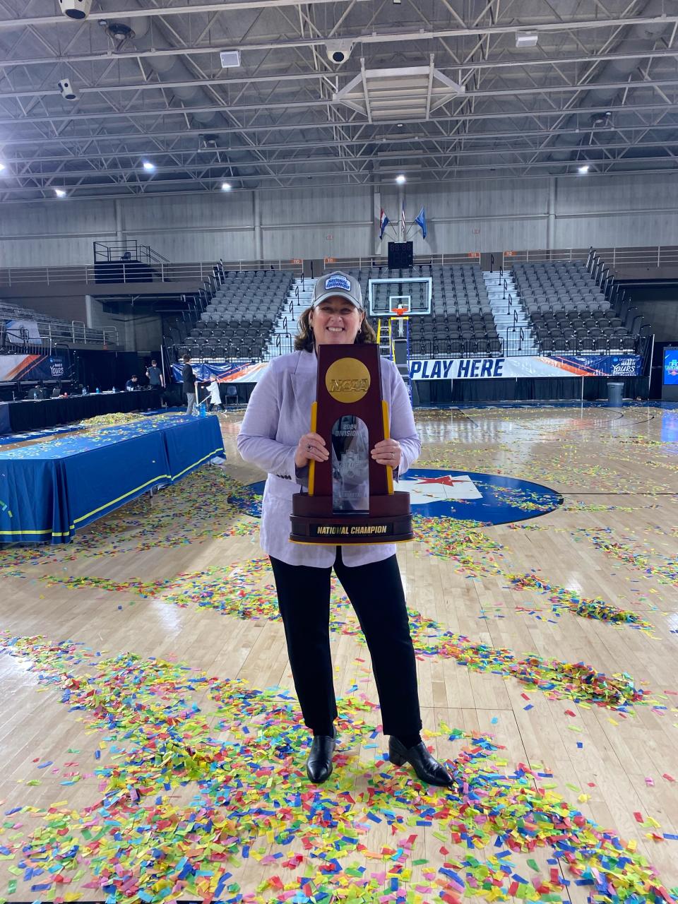 Minnesota State University-Mankato associate coach Amy Sander holds the trophy for a national championship.