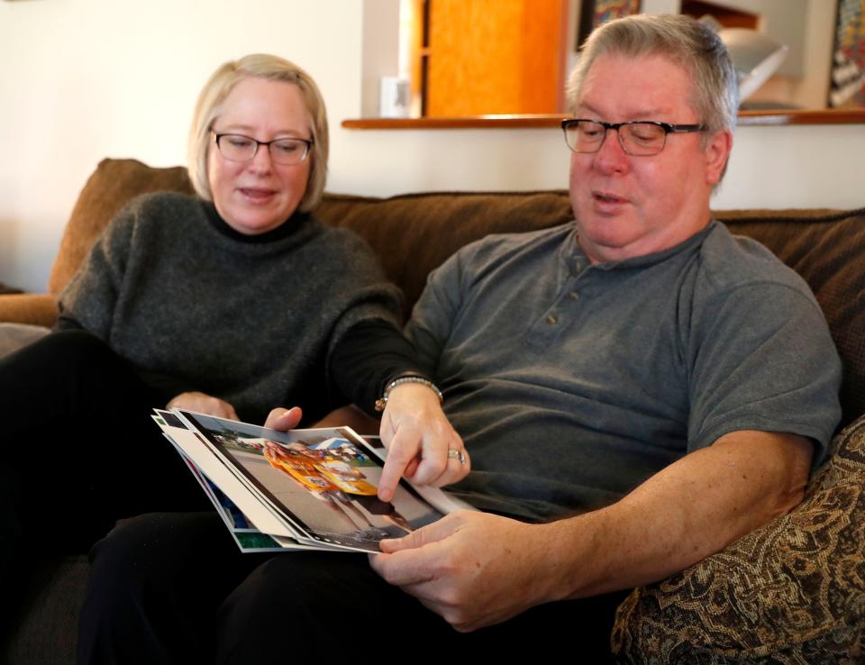 Kristin Schoonveld and her husband Brian Schoonveld point out old family photos Tuesday, Dec. 7, 2021, at their home in Indianapolis.