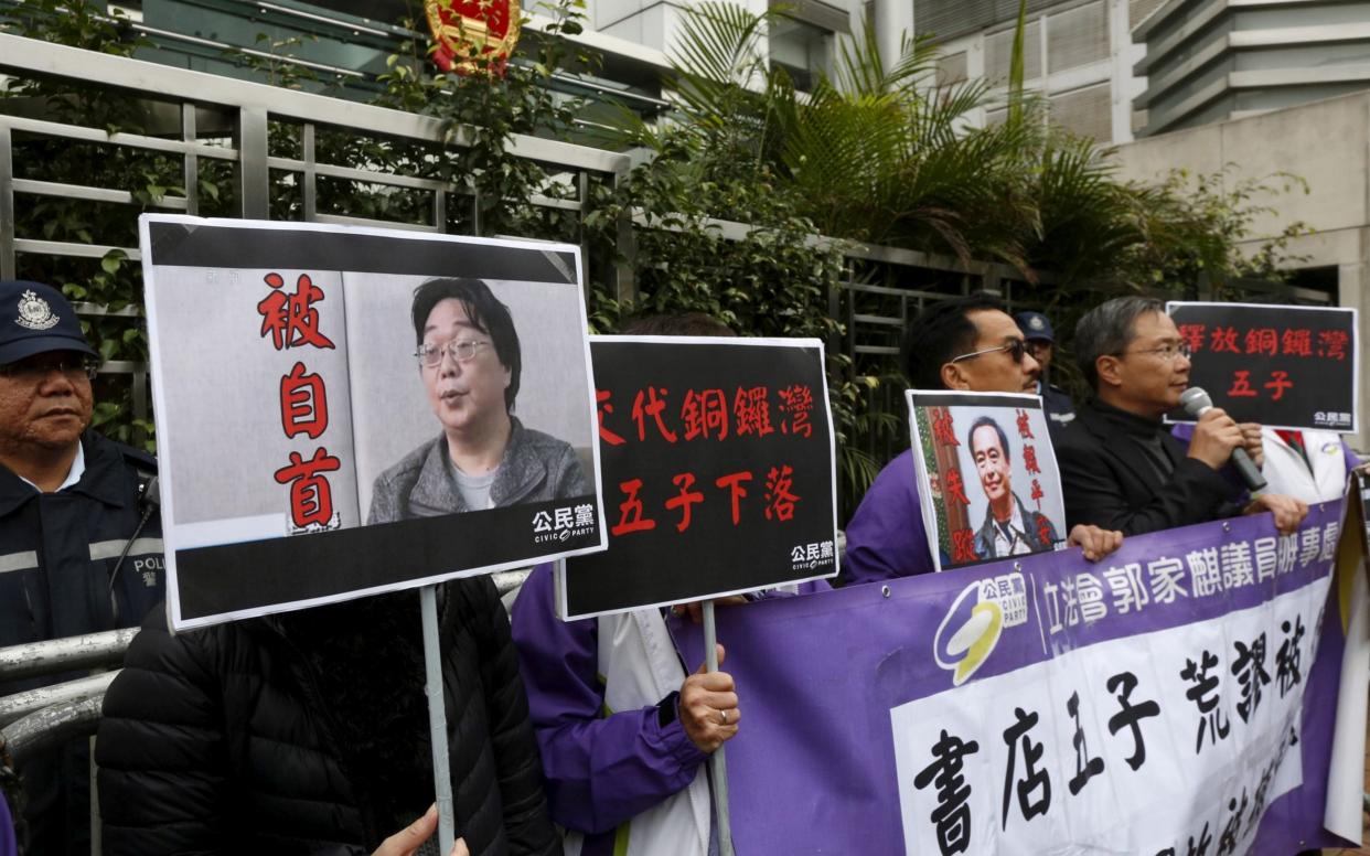 Pro-democracy activists carry a portrait of Gui Minhai (L) during a protest outside the Chinese Liaison Office in Hong Kong in 2016 - REUTERS