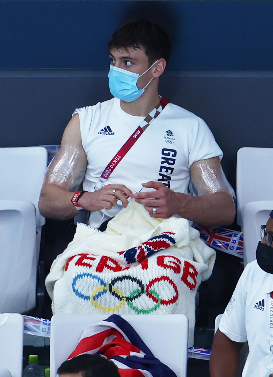 TOKYO, JAPAN - AUGUST 02: Tom Daley of Team Great Britain knits during the Men&#39;s 3m Springboard Preliminary Round on day ten of the Tokyo 2020 Olympic Games at Tokyo Aquatics Centre on August 02, 2021 in Tokyo, Japan. (Photo by Clive Rose/Getty Images)