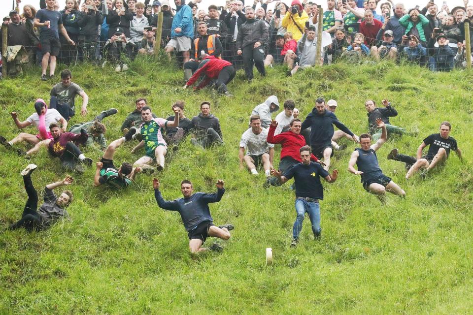 ontestants in the men's downhill race chase the cheese down the hill on June 05, 2022 in Gloucester, England