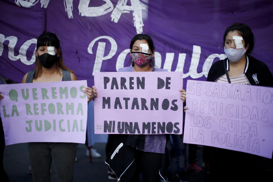 Mujeres con uno de los ojos tapados sostienen carteles durante una protesta contra la violencia de género, en Buenos Aires, Argentina, el miércoles 17 de febrero de 2021. (AP Foto/Natacha Pisarenko)