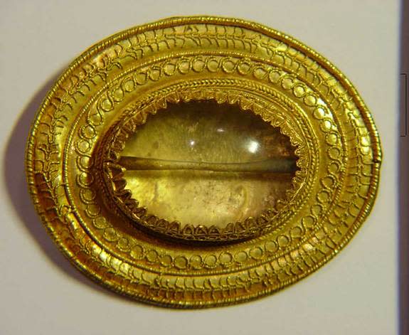 The burial of the warrior was richly adorned and contained more than a dozen gold artifacts. This fibula-brooch, despite being only 2.3 by 1.9 inches in size, contains intricate decorations leading toward the center where a rock crystal bead is mounted. (Photo courtesy Valentina Mordvintseva) <br> <br> <a href="http://www.livescience.com/27271-ancient-treasure-caucasus.html" rel="nofollow noopener" target="_blank" data-ylk="slk:Click here to see the full collection at LiveScience.com;elm:context_link;itc:0;sec:content-canvas" class="link ">Click here to see the full collection at LiveScience.com</a>