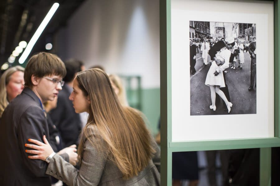 People speak next to a famous photograph taken by Alfred Eisenstaedt of a sailor kissing a nurse in New York's Times Square on V-J Day at the Jewish Museum and Tolerance Center in Moscow on April 14, 2015. Veterans Affairs Secretary Denis McDonough has reversed a department memo shared by a VA undersecretary Tuesday, March 5, 2024, that aimed to ban VA displays of the iconic photograph because it “depicts a non-consensual act” and was inconsistent with the department’s sexual harassment policy. (AP Photo/Alexander Zemlianichenko, File)