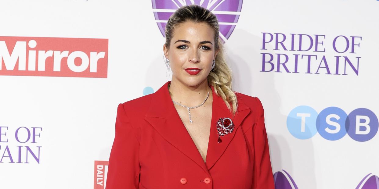 gemma atkinson wearing her hair up in a ponytail and a red suit