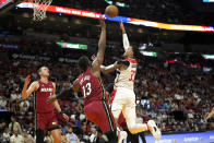 Washington Wizards forward Kyle Kuzma goes to the basket as Miami Heat center Bam Adebayo (13) defends during the first half of an NBA basketball game, Sunday, March 10, 2024, in Miami. (AP Photo/Lynne Sladky)