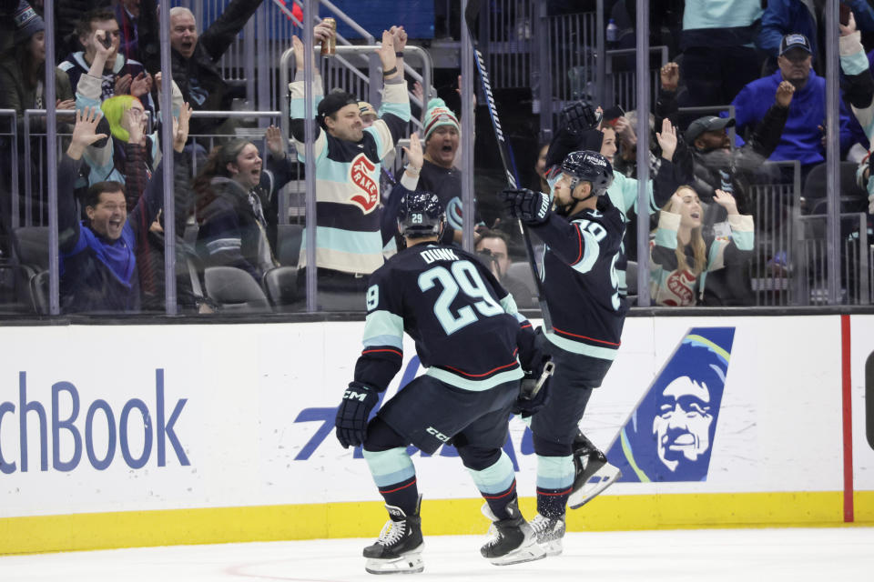 Seattle Kraken left wing Tomas Tatar (90), right, celebrates after his goal with defenseman Vince Dunn (29) as he skates toward fans during the second period of an NHL hockey game against the Ottawa Senators, Thursday, Jan. 4, 2024, in Seattle. (AP Photo/John Froschauer)