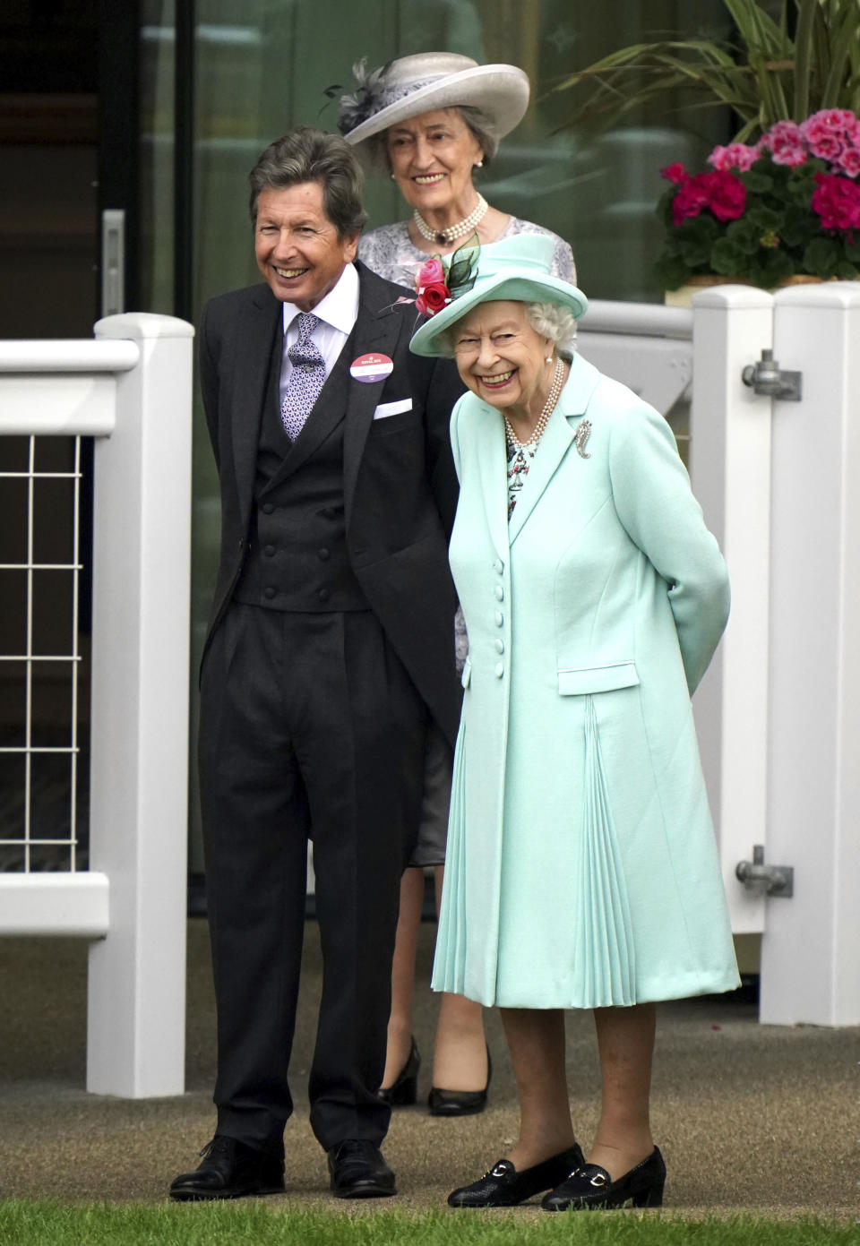 Britain's Queen Elizabeth II, right, stands with racing manager John Warren, during day five of of the Royal Ascot horserace meeting, at Ascot Racecourse, in Ascot, England, Saturday June 19, 2021. (Andrew MatthewsPA via AP)