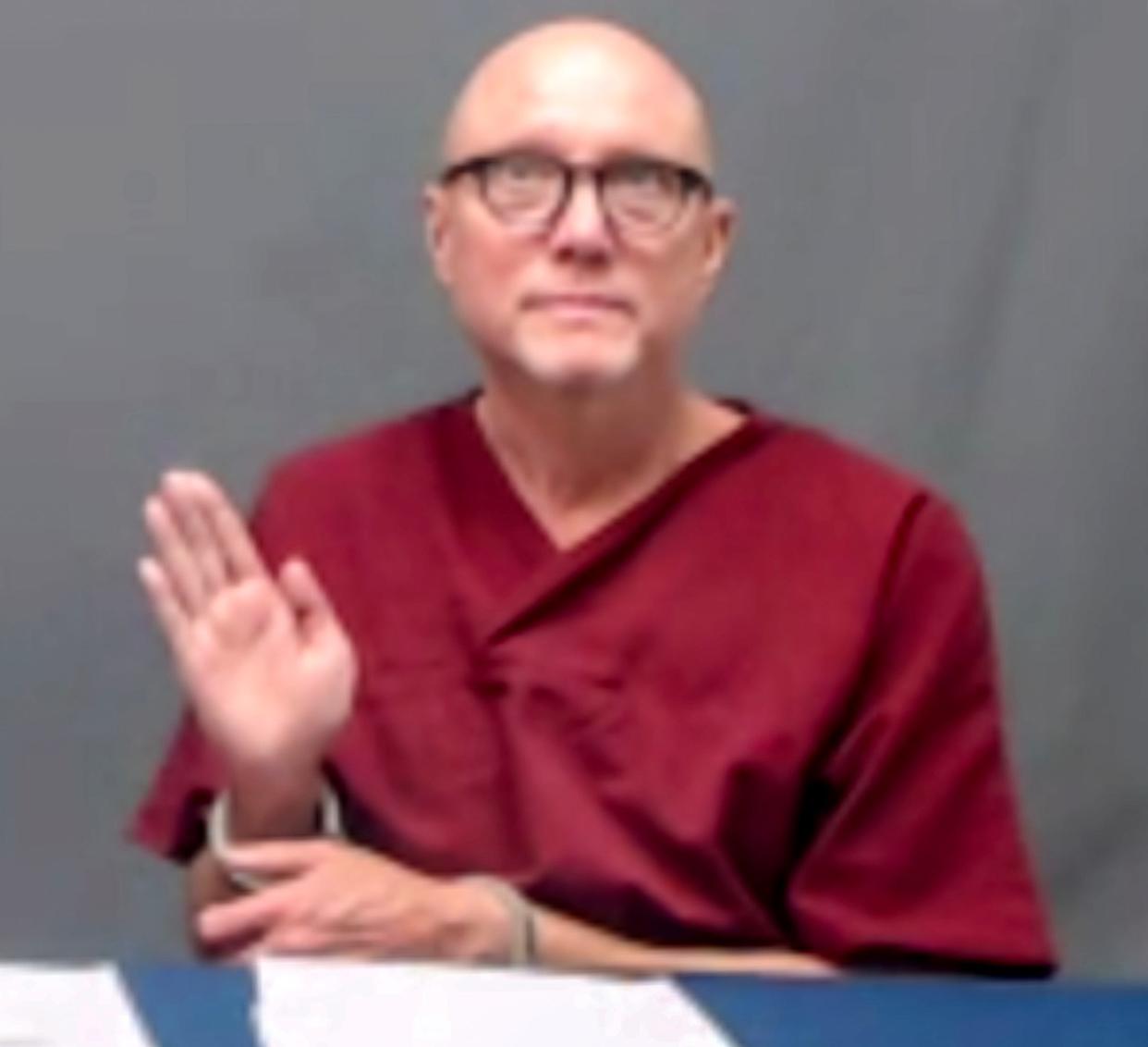 Death row inmate Phillip Hancock swears to tell the truth Wednesday in his video appearance before the Oklahoma Pardon and Parole Board.