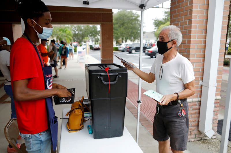 FILE PHOTO: People line up at a polling station as early voting begins in Florida