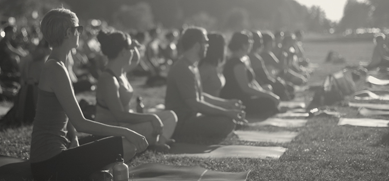 Black and white depiction of a yoga class outdoors.