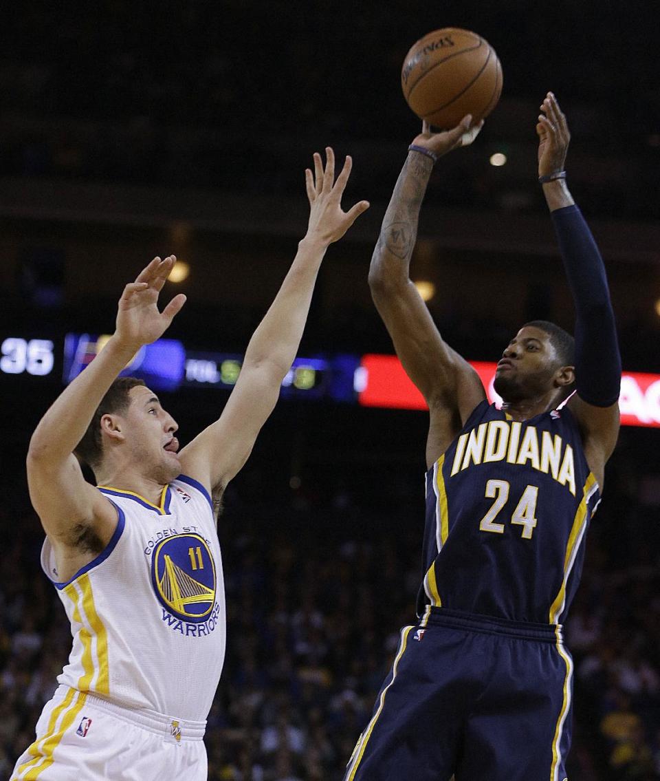 Indiana Pacers' Paul George, right, shoots over Golden State Warriors' Klay Thompson (11) during the first half of an NBA basketball game, Monday, Jan. 20, 2014, in Oakland, Calif. (AP Photo/Ben Margot)