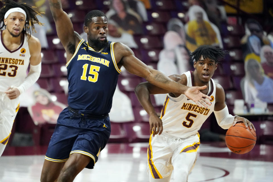 Michigan's Chaundee Brown (15) defends as Minnesota's Marcus Carr (5) drives the ball in the first half an NCAA college basketball game, Saturday, Jan. 16, 2021, in Minneapolis. (AP Photo/Jim Mone)