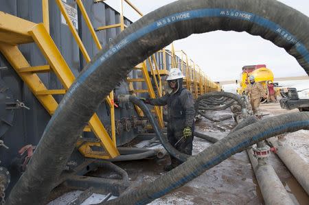 Mody Torres of Select Energy Services monitors water tanks at a Hess fracking site near Williston, North Dakota November 12, 2014. REUTERS/Andrew Cullen