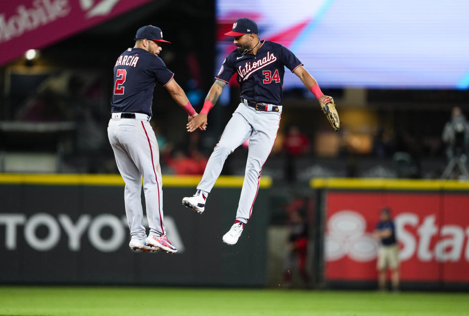 Washington Nationals second baseman Luis Garcia jumps to greet center fielder Derek Hill after the Nationals defeated the Seattle Mainers 7-4 in 11 innings in a baseball game Tuesday, June 27, 2023, in Seattle. (AP Photo/Lindsey Wasson)