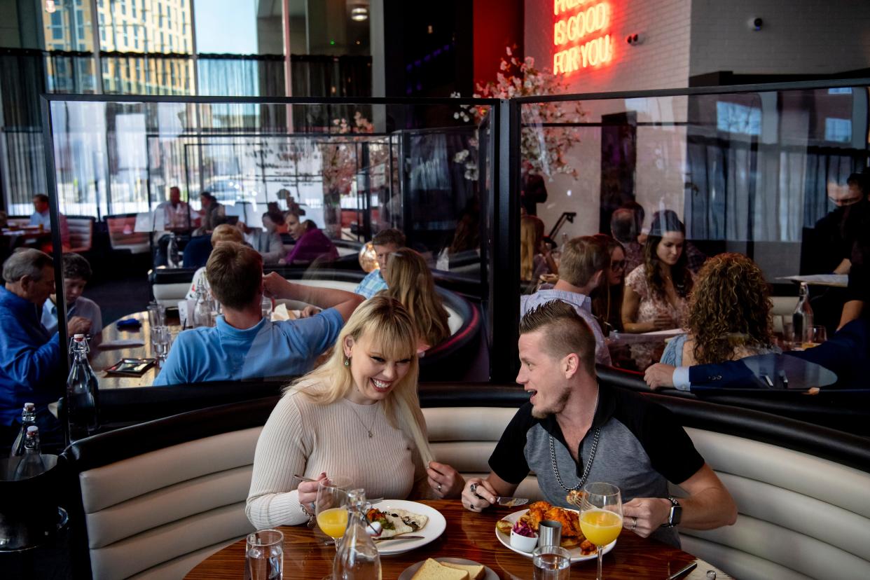 Ashley Beaver and Dakotah Knep of Kansas City, Mo., laugh with each other over their food during brunch service at STK Nashville on Sunday, April 4, 2021 in Nashville, Tenn.