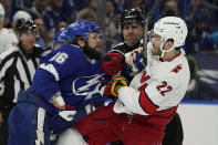 NHL linesman Lonnie Cameron (74) gets between Tampa Bay Lightning right wing Nikita Kucherov (86) and Carolina Hurricanes defenseman Brett Pesce (22) as they battle during the first period in Game 3 of an NHL hockey Stanley Cup second-round playoff series Thursday, June 3, 2021, in Tampa, Fla. (AP Photo/Chris O'Meara)