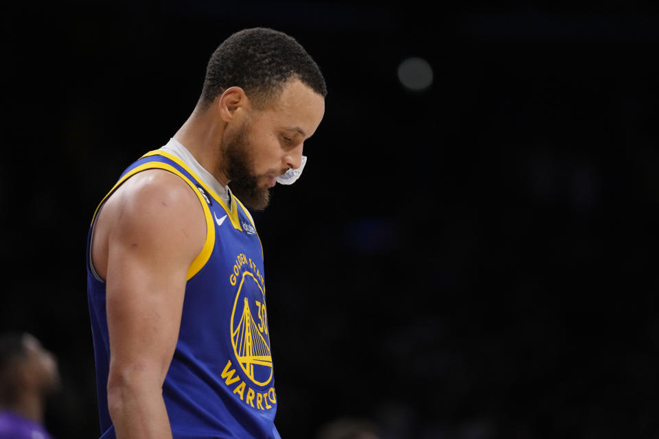 Golden State Warriors guard Stephen Curry walks on the court in at the closing minutes of a loss to the Los Angeles Lakers during the second half in Game 6 of an NBA basketball Western Conference semifinal series Friday, May 12, 2023, in Los Angeles. (AP Photo/Ashley Landis)