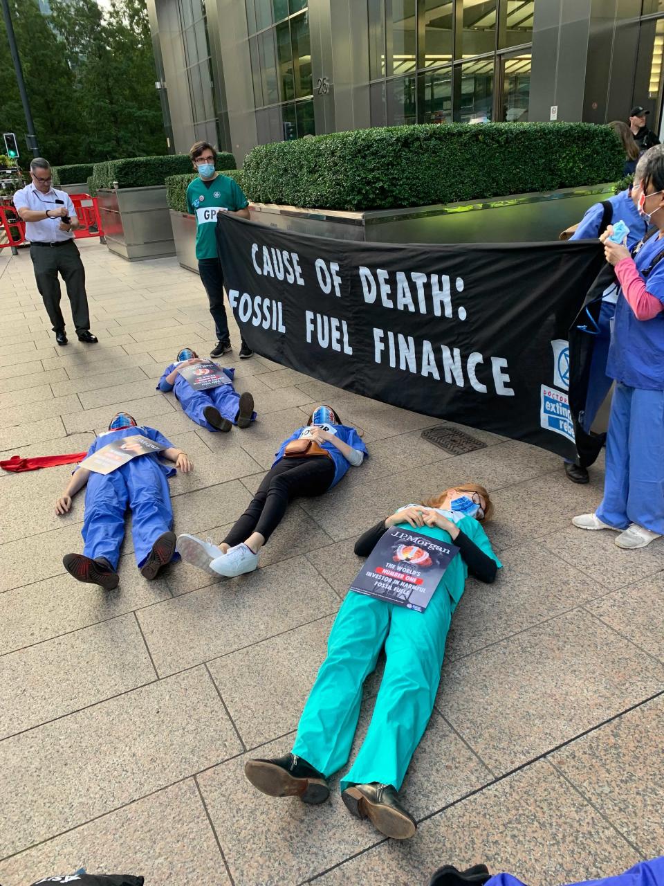 Protesters dressed in their scrubs lay on the floor and held banners in Canary Wharf (The Independent)