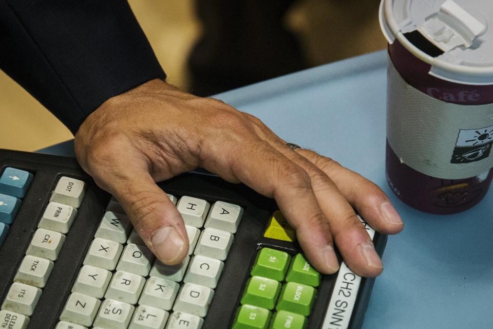 A trader’s hand rests on his keyboard next to a cup of coffee on the floor of the New York Stock Exchange shortly after the opening bell, New York, June 15, 2015. REUTERS/Lucas Jackson