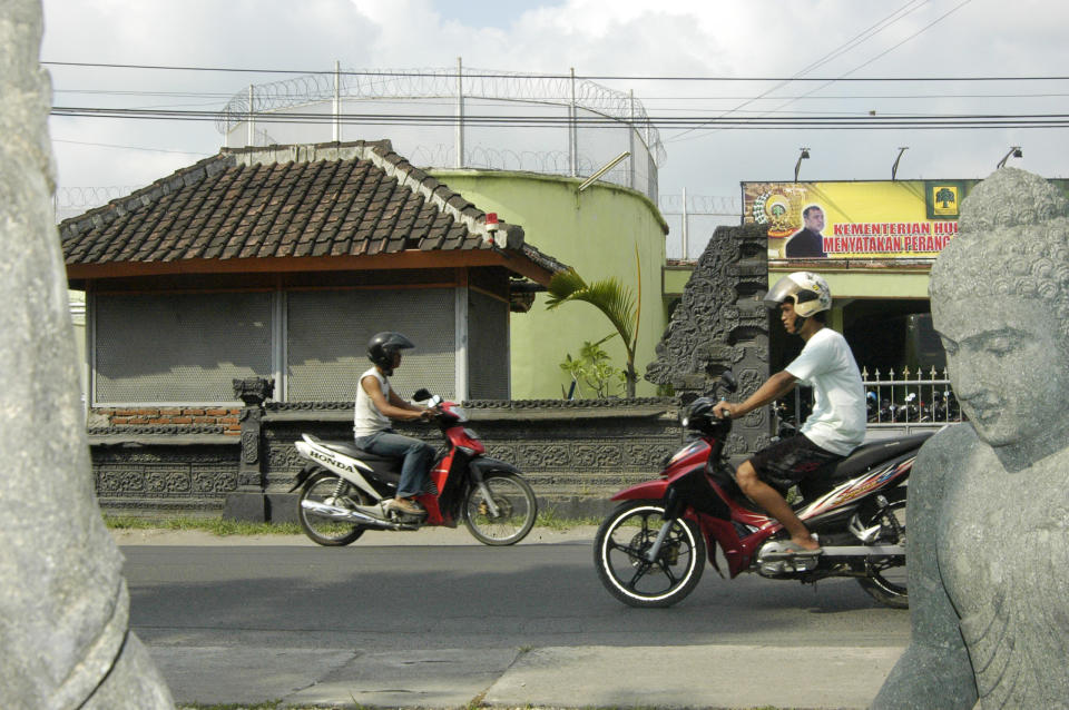 Two motorcyclists pass each other on a Bali road.