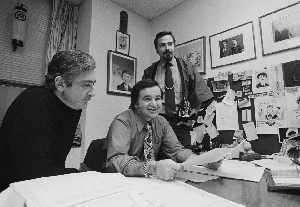 FILE - In this 1972 file photo, "Mad" magazine Editor Al Feldstein, center, sits with Art Director John Putnam, left, and a freelancer named Jack, at the magazine's New York headquarters. Feldstein, whose 28 years at the helm of Mad transformed the satirical magazine into a pop culture institution, died Tuesday, April 29, 2014. He was 88. (AP Photo/Jerry Mosey, File)