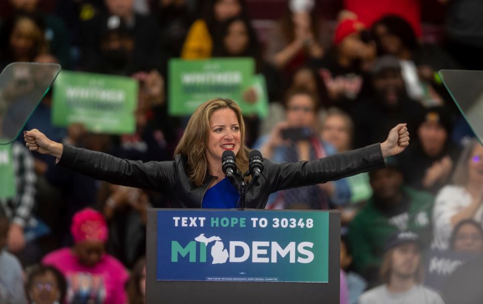 Secretary of State of Michigan Jocelyn Benson puts her arms in the air as she gives a speech in front of a large crowd during a rally inside a gymnasium at Renaissance High School in Detroit on Saturday, Oct. 29, 2022. 
