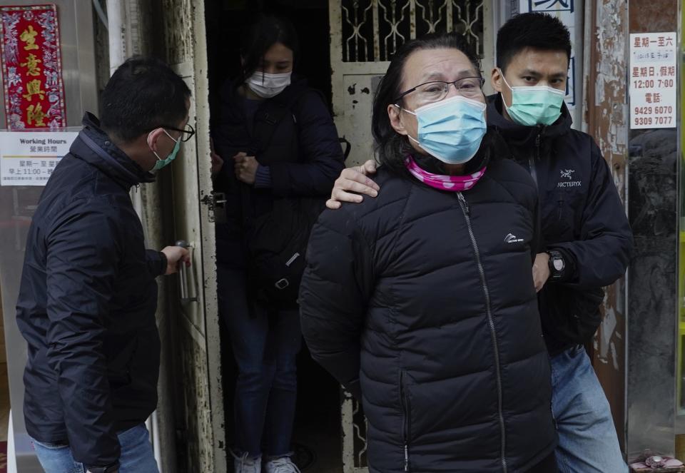 District councillor and lawyer Daniel Wong Kwok-tung, center, is escorted by police outside his office after police search in Hong Kong, Thursday, Jan. 14, 2021. Wong, a member of the city's Democratic Party, is known for providing legal assistance to hundreds of protesters arrested during the anti-government protests in Hong Kong in 2019. Hong Kong national security police on Thursday arrested a lawyer and 10 others on suspicion of helping 12 Hong Kongers try to flee the city, local media reported in the latest arrests in an ongoing crackdown on dissent. (AP Photo/Vincent Yu)