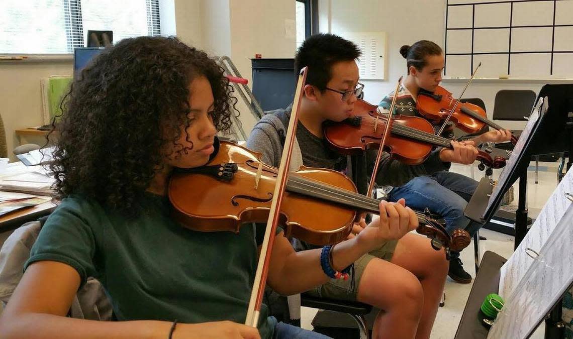 From left, East Millbrook Middle School students Taylin Fleming, Justin Trinh and Skyler Wechsberg rehearse classical music.