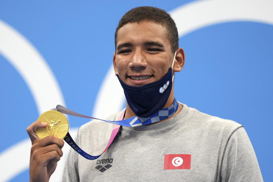 Ahmed Hafnaoui, of Tunisia, poses with his gold medal after winning final of the men's 400-meter freestyle at the 2020 Summer Olympics, Sunday, July 25, 2021, in Tokyo, Japan. (AP Photo/Matthias Schrader)