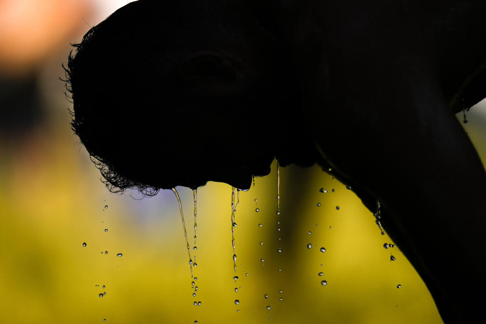 A wrestler cools off as he competes during the 661st annual Historic Kirkpinar Oil Wrestling championship, in Edirne, northwestern Turkey, Saturday, July 2, 2022. The festival is part of UNESCO's List of Intangible Cultural Heritages. (AP Photo/Francisco Seco)