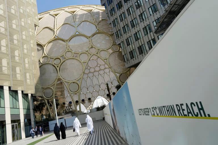 Varias personas pasan junto al Al Wasl Dome de Expo City antes de la Cumbre Climática COP28 de Naciones Unidas, el 28 de noviembre de 2023, en Dubái, Emiratos Árabes Unidos. (AP Foto/Peter Dejong)