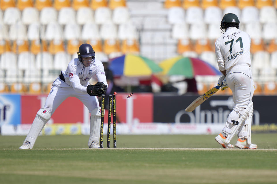 England's Jamie Smith, left, removes bails to stump out to Pakistan's Naseem Shah during the fifth day of the first test cricket match between Pakistan and England, in Multan, Pakistan, Friday, Oct. 11, 2024. (AP Photo/Anjum Naveed)