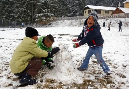 Migrants play in the snow before passing the Austrian-German border in Wegscheid in Austria, near Passau November 22, 2015. REUTERS/Michael Dalder/Files