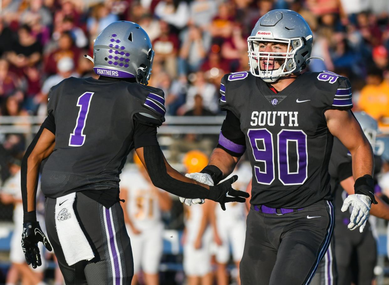 Bloomington South’s D’Andre Black (1) and Noah Fox (90) high-five during the North-South football game at South on Friday, September 8, 2023.