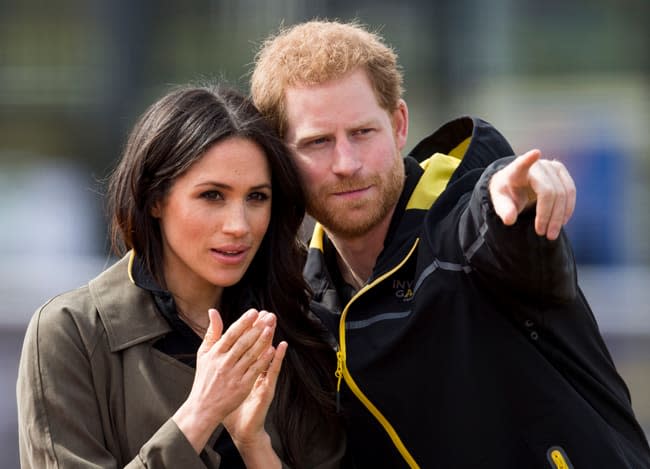 Prince Harry pointing alongside Meghan Markle