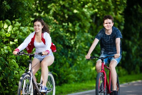 <span class="caption">Green spaces near schools was also linked to higher fitness levels in teens.</span> <span class="attribution"><a class="link " href="https://www.shutterstock.com/image-photo/urban-bicycle-teenage-girl-boy-cycling-603987185" rel="nofollow noopener" target="_blank" data-ylk="slk:Jacek Chabraszewski/ Shutterstock;elm:context_link;itc:0;sec:content-canvas">Jacek Chabraszewski/ Shutterstock</a></span>