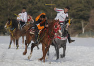 A rider throws the javelin during a game of Cirit, a traditional Turkish equestrian sport that dates back to the martial horsemen who spearheaded the historical conquests of central Asia's Turkic tribes, between the Comrades and the Experts local sporting clubs, in Erzurum, eastern Turkey, Friday, March 5, 2021. The game that was developed more than a 1,000 years ago, revolves around a rider trying to spear his or her opponent with a "javelin" - these days, a rubber-tipped, 100 centimeter (40 inch) length of wood. A rider from each opposing team, which can number up to a dozen players, face each other, alternately acting as the thrower and the rider being chased. Cirit was popular within the Ottoman empire, before it was banned as in the early 19th century. However, its popularity returned as is now one of many traditional sports encouraged by the government and tournaments are often arranged during festivals or to celebrate weddings. (AP Photo/Kenan Asyali)