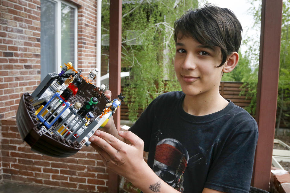 Danylo Boichuk, 12, shows his one of his LEGO constructions during an interview at his home in the village of Gorenichi outside Kyiv, Ukraine, on Tuesday, May 5, 2020. Ukraine has been under a COVID-19 coronavirus quarantine since March 12. Danylo envies his cat, Kari, who is able to escape from the family house and run free. Because of the pandemic, his family had to cancel a vacation in Bulgaria, and he worries a lot about closed borders. (AP Photo/Efrem Lukatsky)