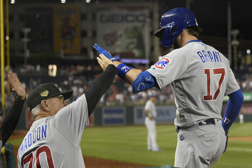 Chicago Cubs' Kris Bryant (17) celebrates his two-run home run with manager Joe Maddon (70) during the ninth inning of a baseball game against the Washington Nationals, Friday, May 17, 2019, in Washington. (AP Photo/Nick Wass)