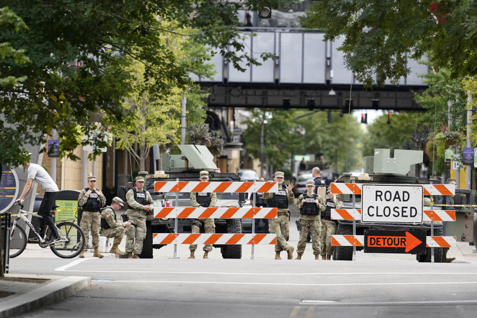 Police stand near a barricade, Friday, Sept. 25, 2020, in Louisville. Breonna Taylor's family demanded Friday that Kentucky authorities release all body camera footage, police files and the transcripts of the grand jury hearings that led to no charges against police officers who killed the Black woman during a March drug raid at her apartment. (AP Photo/Darron Cummings)