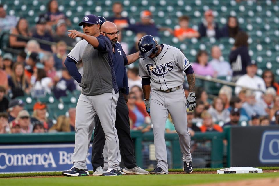 Rays manager Kevin Cash, from left, signals for a pinch runner as team trainer Joe Benge helps shortstop Wander Franco to the dugout from third base against the Tigers in the first inning on Friday, Sept. 10, 2021, at Comerica Park.