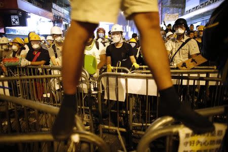 Pro-democracy protesters stand by a barricade as they prepare for a confrontation with riot police at the Mongkok shopping district of Hong Kong October 20, 2014. REUTERS/Carlos Barria